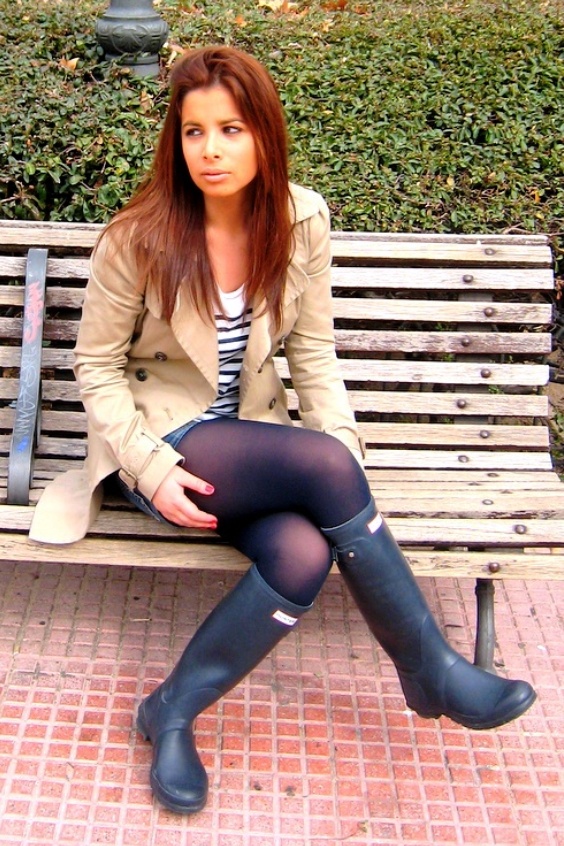 Woman wearing shorts, black tights and black rain boots