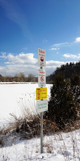 Warning signs of the dangers of playing on ice or water in the stormwater facilities in Earl Bales Park, Toronto.