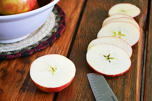 Slicing apples on wooden surface