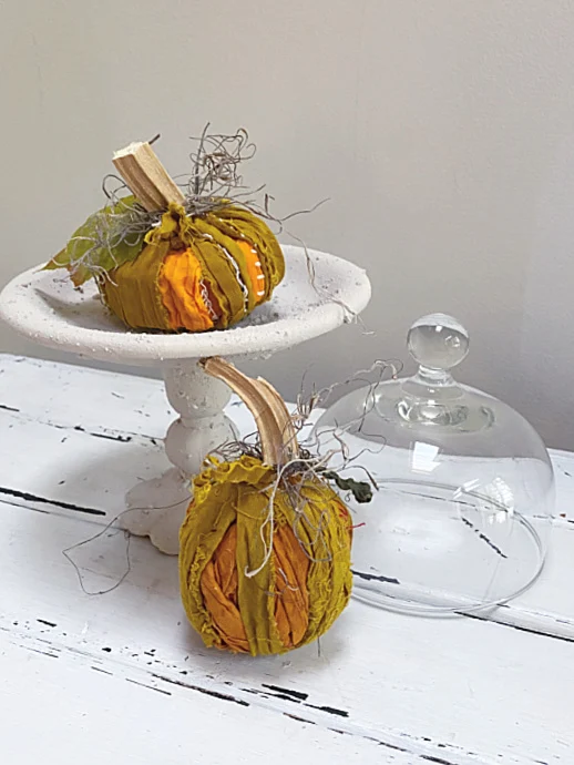 rag pumpkins on a pedestal dish