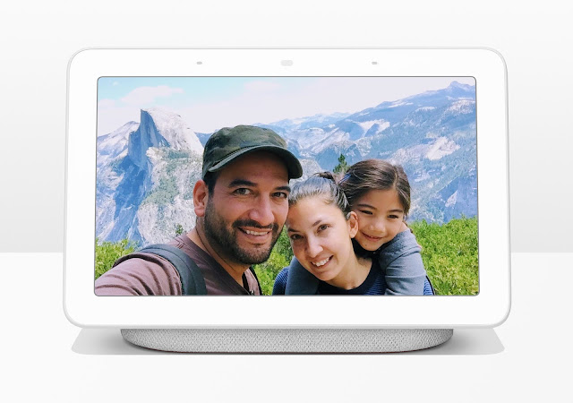 Photo of Home Hub device, displaying a family photo with a mum, dad and child