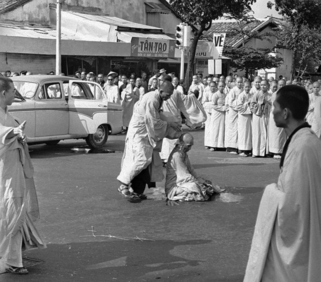 Thich Quang Duc is doused with gasoline while calmly sitting down in the traditional Buddhist meditative lotus position.