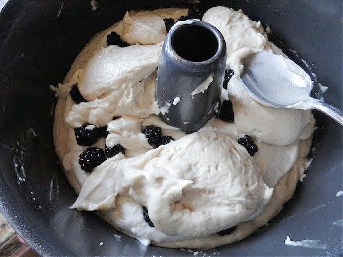 Coffee Cake batter being spread over blackberries and cream cheese filling.
