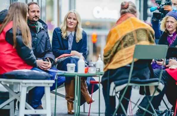 Crown Princess Mette-Marit wore a navy blue wool cashmere coat and camel leather boot. Peter Pan collar blue and white blouse with gingham check