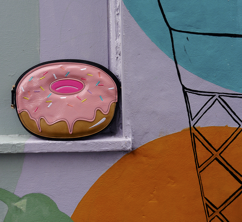 Donut novelty clutch bag from New Look as worn by UK fashion bloggers Donut novelty clutch bag from New Look as worn by UK fashion bloggers propper against candy coloured wall