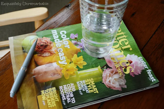 Better Homes and Gardens Magazine on coffee table with pen and cup on top