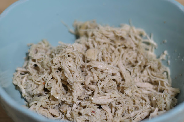 Pre-cooked and shredded chicken in a bowl.