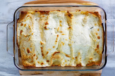 pan of creamy chicken and mushroom stuffed baked crepes in pan fresh from oven