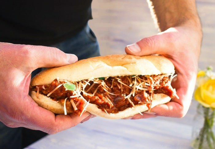 A man holding a vegan 'meatball' sub