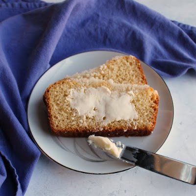 This sweet bread is topped with buttery crumb topping for a delicious treat. Bake it as a loaf or as a round for an extra special treat with your coffee or tea. It is an Easter time tradition, but is great all year long. slice of placek loaf spread with butter on small plate