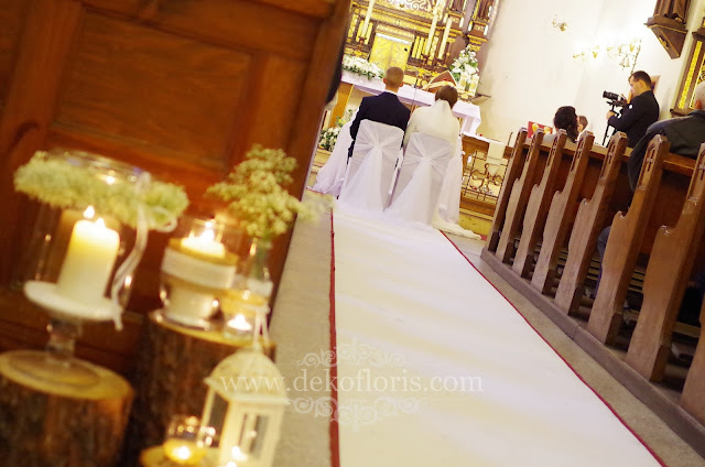 Rustykalna dekoracja ślubna wejście do kościoła świece, pieńki i gipsówka Prudnik