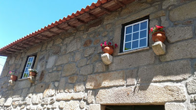 casa de pedra com vasos de flores nas janelas