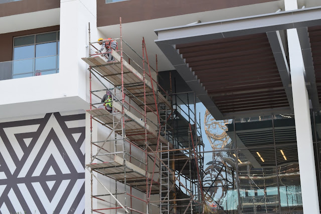 Construction workers on a scaffold working on a wall