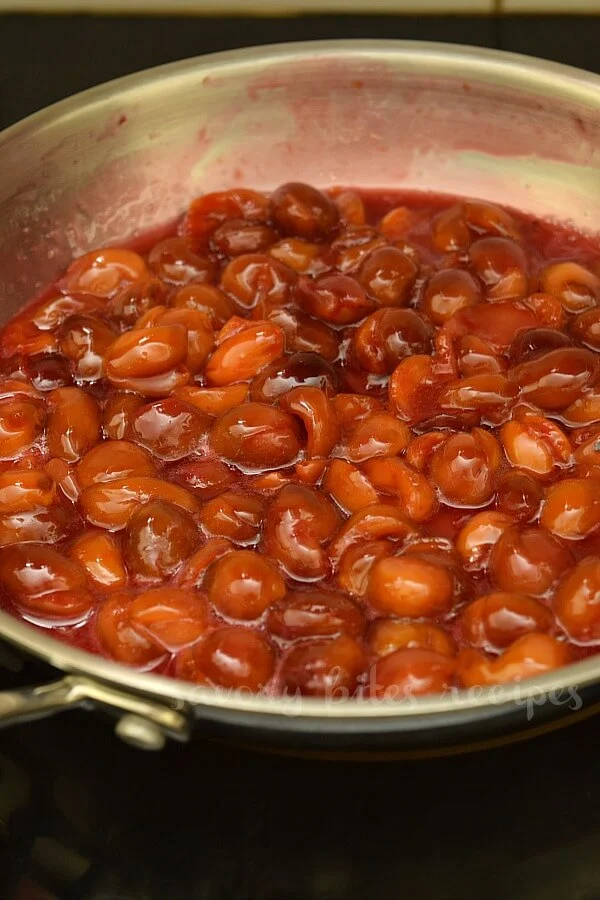 a pan with fresh cherries cooking to make filling