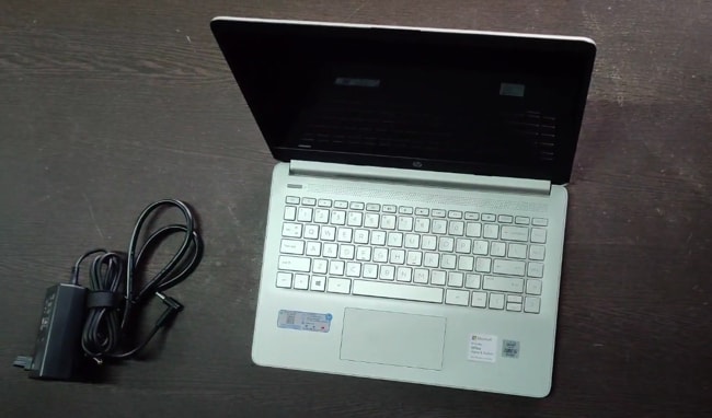 All-plastic build of HP 14s dr1009tu laptop with its charging accessories.