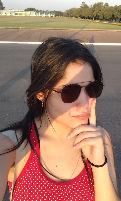city tour brasilia em onibus panorâmico selfie de mulher jovem com oculos escuro e blusa vermelha de bolinhas brancas