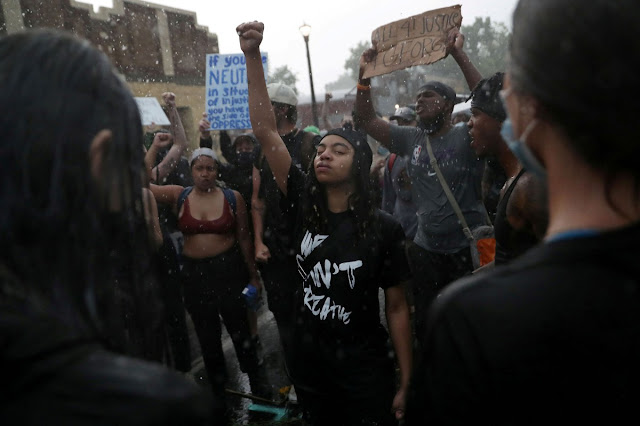 Kobieta trzyma rękę wzniesioną podczas demonstarcji Blac Lives Matter