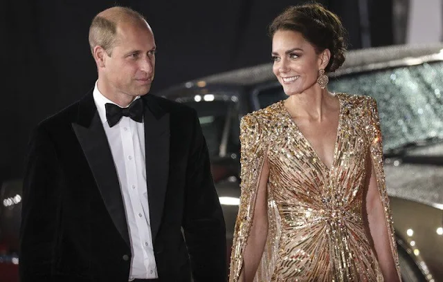 Kate Middleton wore a shimmering cape gown by Jenny Packham. Gold earrings. Aquazzura Fenix gold metallic leather pumps