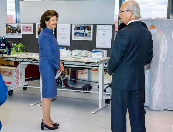 Queen Silvia wore and blue jacket and skirt, skirt suit. She is wearing gold earrings and gold bracelet