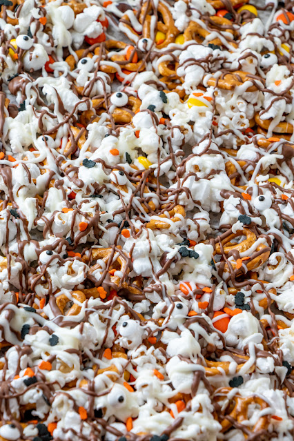 Sheet pan with popcorn, candy, pretzels, and covered in chocolate drizzle