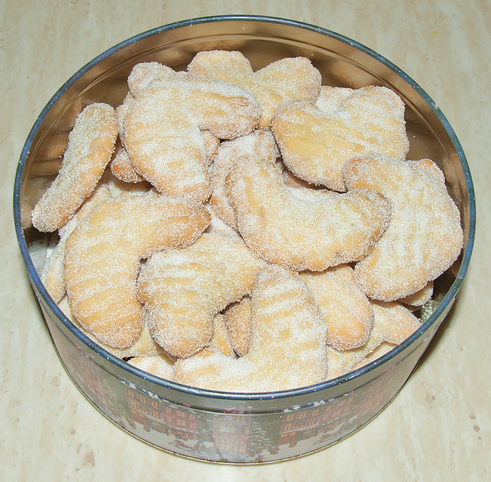 The finished almond crescent cookies packed into a cookie tin, ready to eat or store.