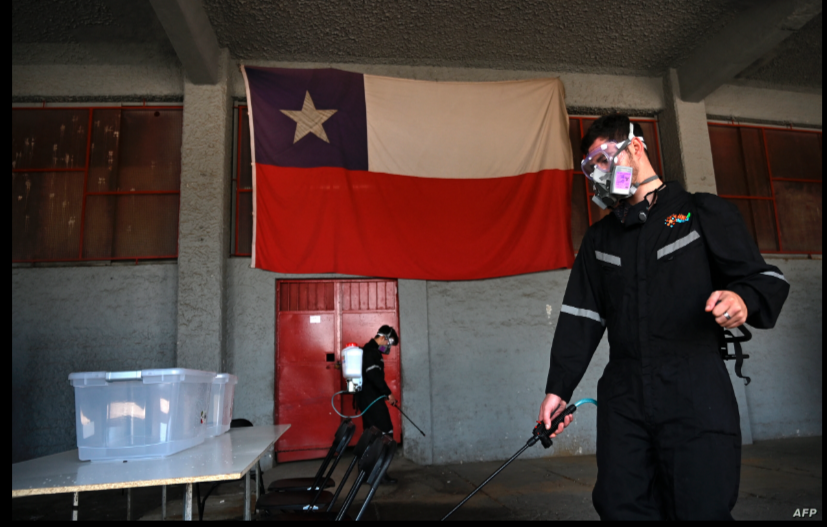 En esta foto de archivo tomada el 24 de octubre de 2020, trabajadores desinfectan un colegio electoral en vísperas de la votación del referéndum constitucional nacional en Santiago, en medio de la pandemia del coronavirus COVID-19 / AFP