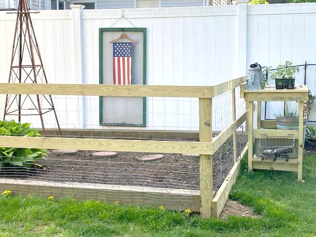 Garden gate with painted American flag hanging in the background
