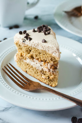 slice of layer coffee and cream sponge cake on plate with fork