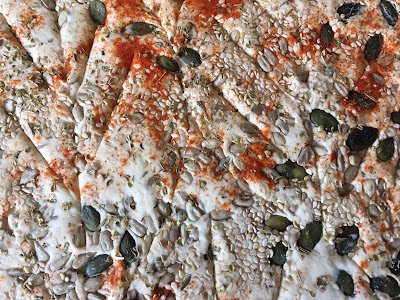 Close up of cracker toppings, seeds and paprika