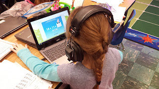 Student wearing headphones working on a Chromebook.