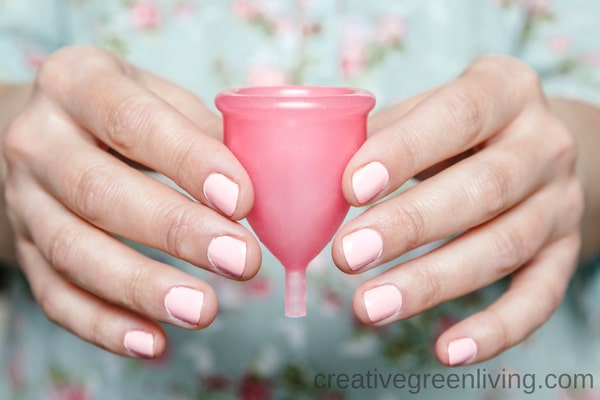 menstrual cup dangers - lead, cadmium and heavy metals in menstrual cups - woman holding a pink menstrual cup