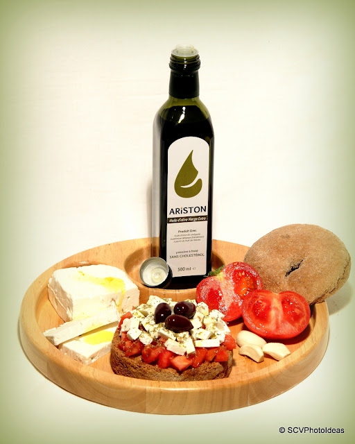 Ariston Olive oil bottle in wooden plate w/ tomato-feta cheese-cracker