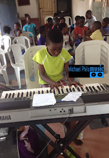 young pianist playing imela by nathaniel Bassey
