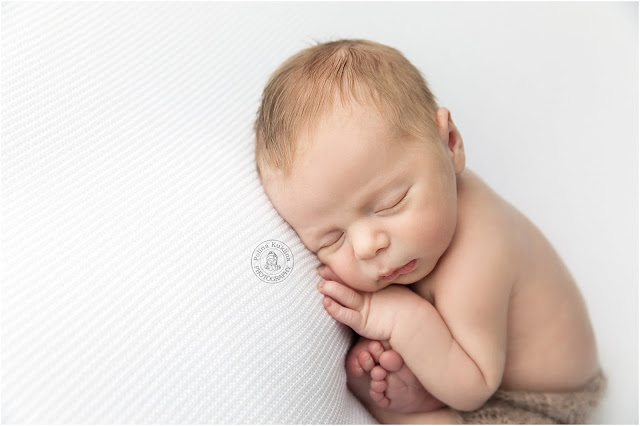 Sleeping baby on a white background in a taco pose
