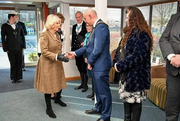 Camilla arrived at the hospice in a smart brown tweed two-piece, pairing the outfit with a simple cream blouse with over-the-knee boots