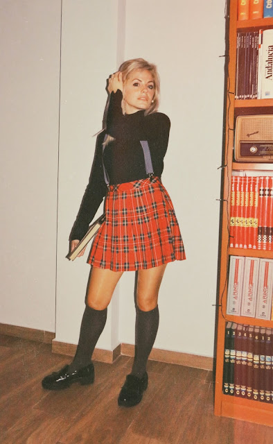 Alejandra Colomera vestida con jersey azul, falda roja cuadros escoceses, tirantes en color gris, calcetas gris y zapatos estilo colegial negro