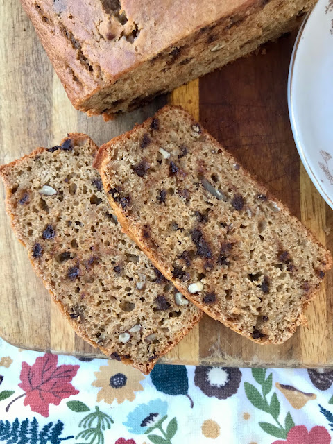 Close-up of two slices of chocolate chip pecan pumpkin bread.