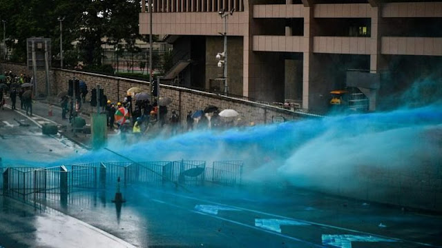 Polícia dispara saraivadas de gás lacrimogêneo para dispersar os manifestantes que cercavam a sede do governo de Hong Kong.