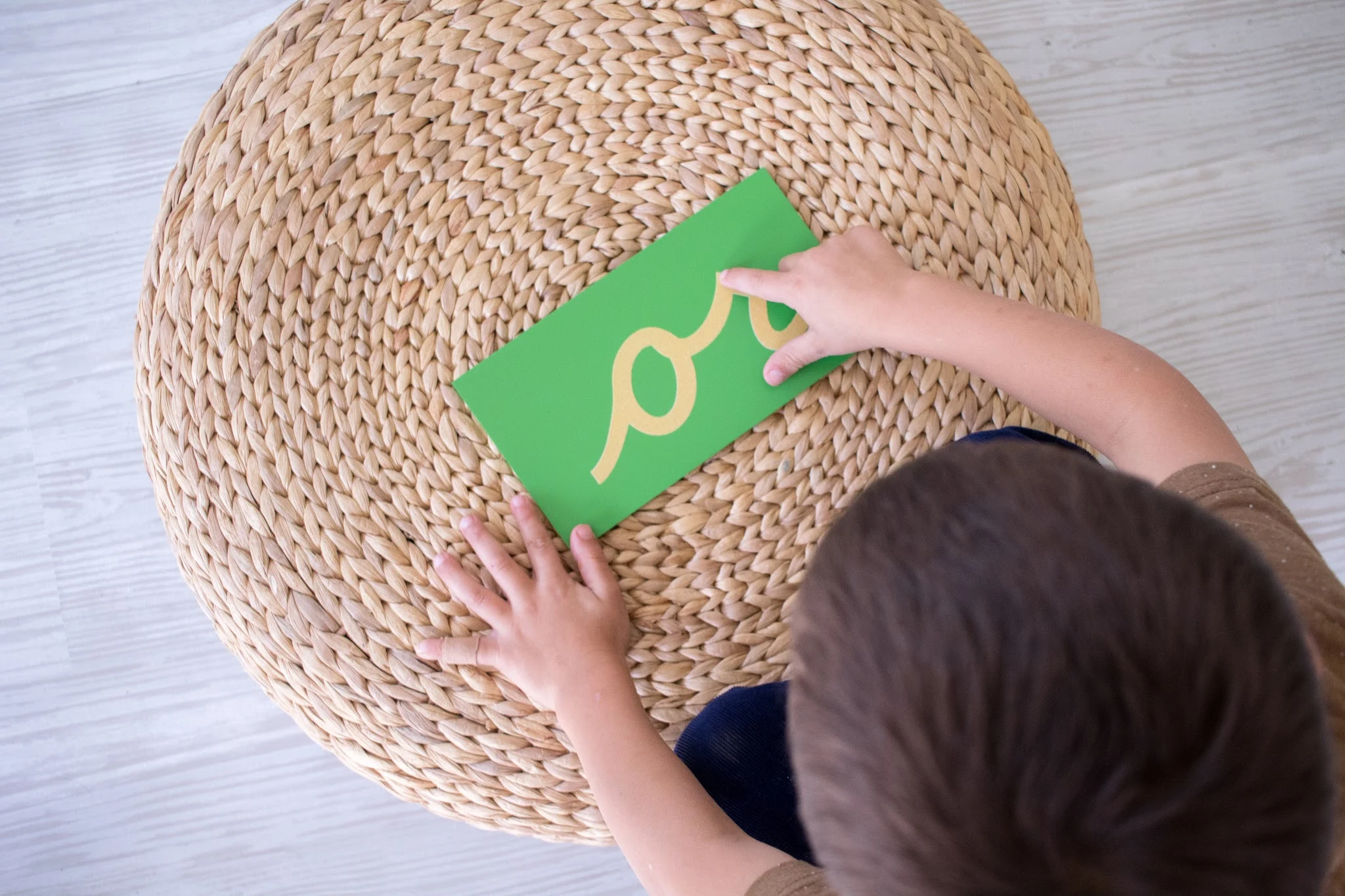 Montessori child traces sandpaper letter at home