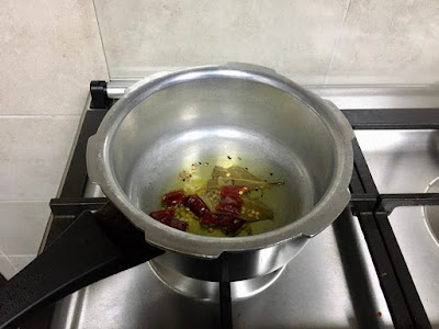 Frying cumin seeds, asafoetida, green chilli, dry red chilli and the bay leaf