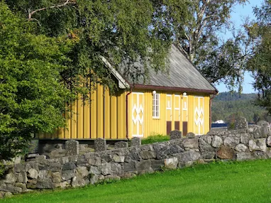 Yellow house behind Valsøyfjord Church on a 2 week Norway road trip itinerary