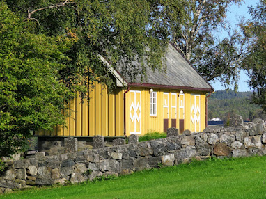 Yellow house behind Valsøyfjord Church on a 2 week Norway road trip itinerary
