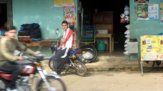 Young man on a motorbike near a local shop in Carapegua