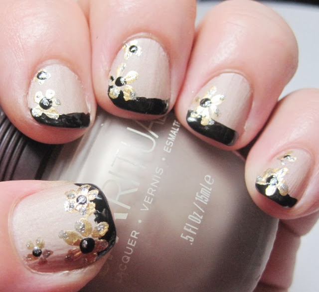 Gold flowers over a black French tip and nude nail