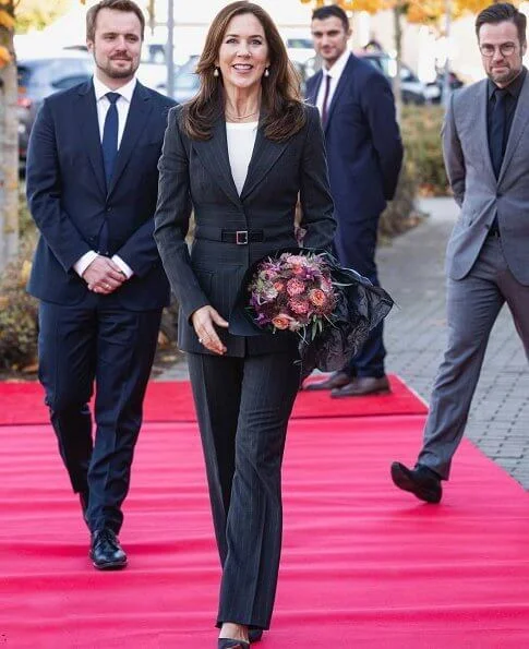 Healthcare Denmark. dark grey pinstripe belted blazer, pinstripe blazer pants suit. Crown Princess Mary wore a drop earrings from Marianne Dulong