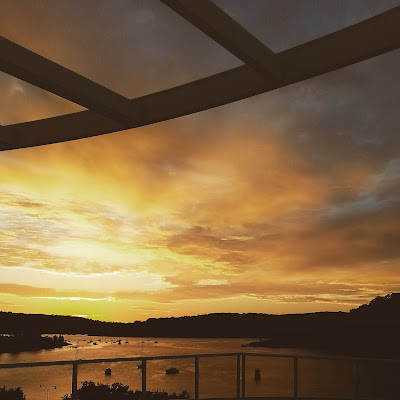 View from a balcony, across an inlet at sunrise.