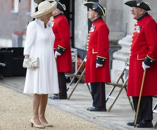 The Duchess of Cornwall wore a white embroidered coat dress with beige leather shoes, and beige hat and she carried beige clutch