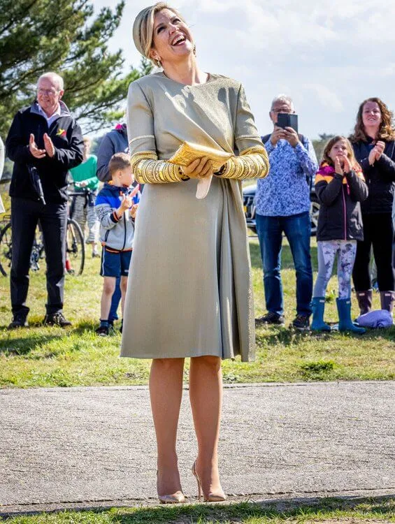 Queen Maxima wore an embellised draped midi dress by Claes Iversen. Gianvito Rossi gold plexi pumps. Begum Khan clutch bag