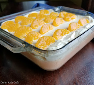 Creamy orange jello dotted with mandarin slices and topped with a fluffy vanilla topping makes for a perfectly refreshing and delicious orange creamsicle jello salad! layers of orange jello salad in dish, ready to serve