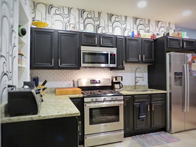 updated kitchen with black cabinets and custom blue grout